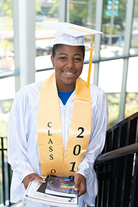 teen smiling in cap and gown