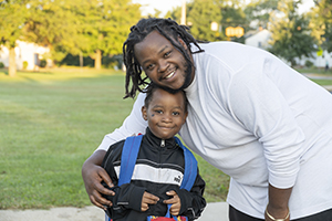 man smiling with son walking to school