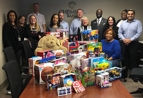 CFS Employees posing with a table full of donated children's toys
