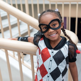 Young African American girl with costume and mask on